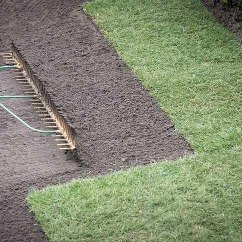 Preparing top soil and laying turf for new lawn